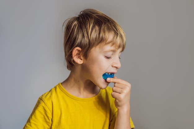 Un niño de seis años muestra un entrenador miofuncional Ayuda a equilibrar los dientes en crecimiento y la mordida correcta Desarrolla el hábito de respirar por la boca Corrige la posición de la lengua