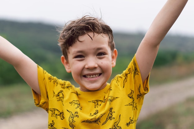 Un niño de seis años sonríe a la cámara en el parque Niño feliz riendo y jugando en el día de verano