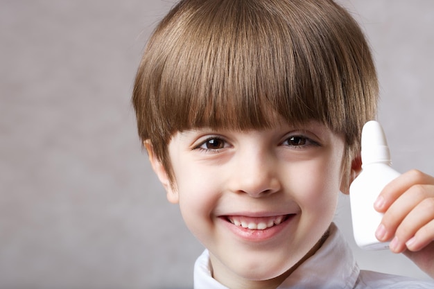 Niño de seis años con spray nasal. De cerca