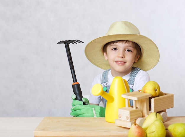 Niño de seis años vestido de jardinero. De cerca