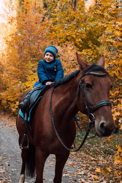 Niño sentado a caballo y sonriendo