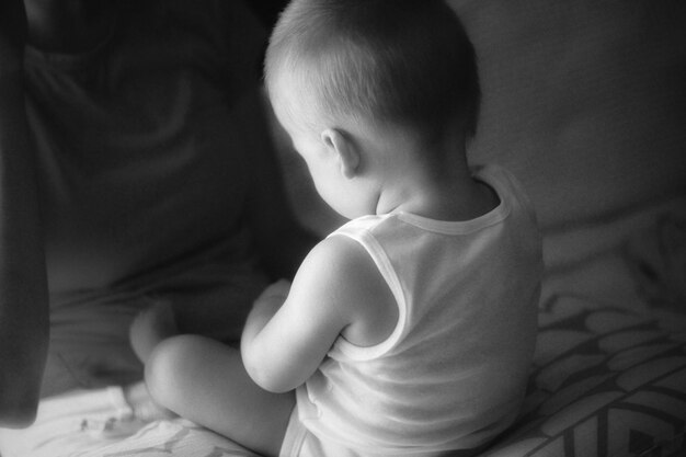 Foto niño sentado en la cama por la noche