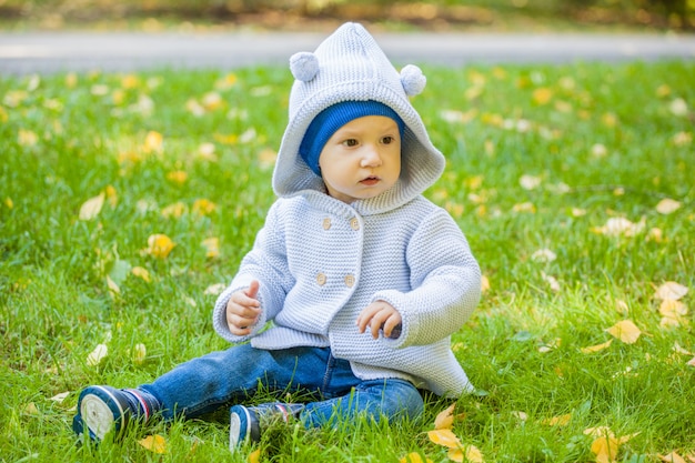 Niño sentado en el césped del parque