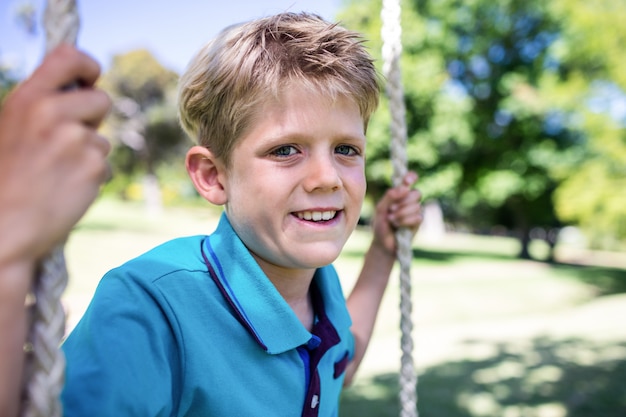 Niño sentado en un columpio en el parque