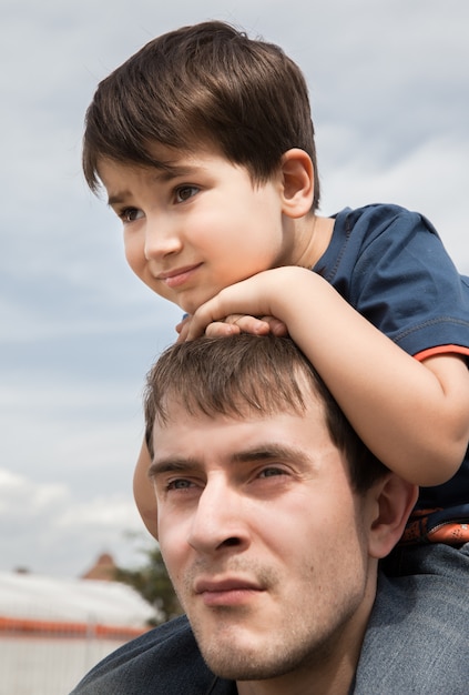 Foto niño sentado en el cuello de su padre.