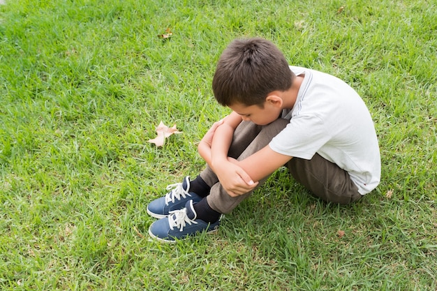 Foto niño sentado en la hierba