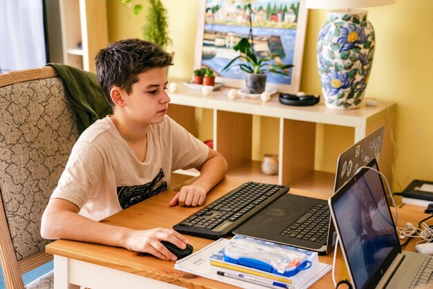 Niño sentado junto al escritorio con una foto de computadora portátil