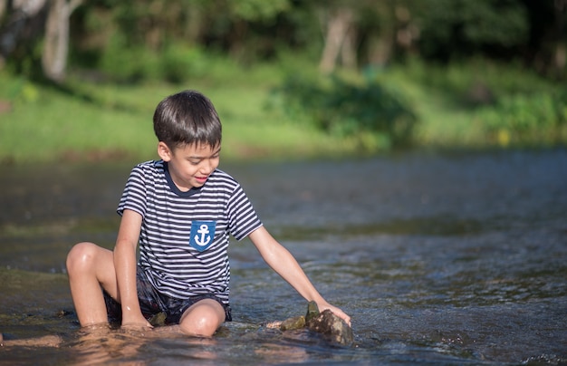 Niño sentado juntos en el canal del río