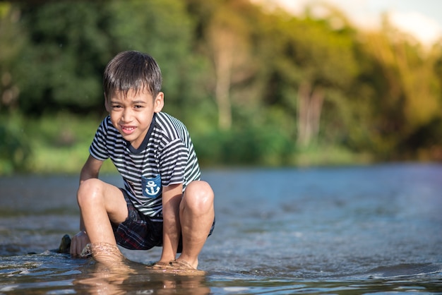 Niño sentado juntos en el canal del río