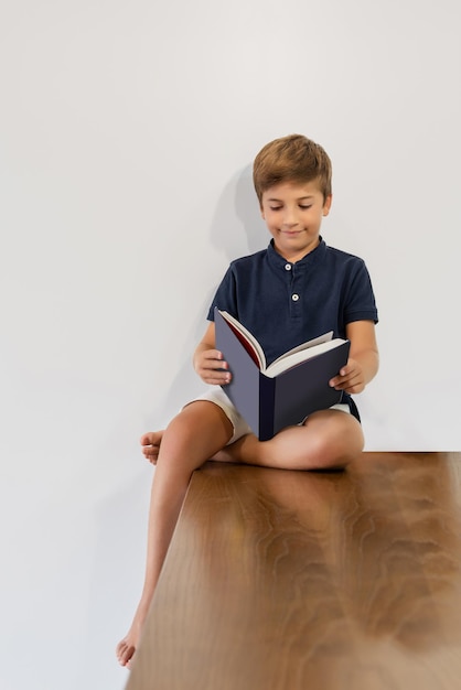 Niño sentado leyendo un libro Aprendiendo y estudiando Regreso a la escuela Animando a los jóvenes a leer