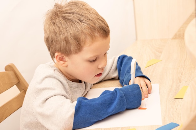 Niño sentado a la mesa y dibujando Concepto de educación en el hogar o actividades de desarrollo