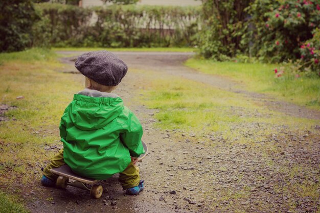 Foto niño sentado en una patineta.