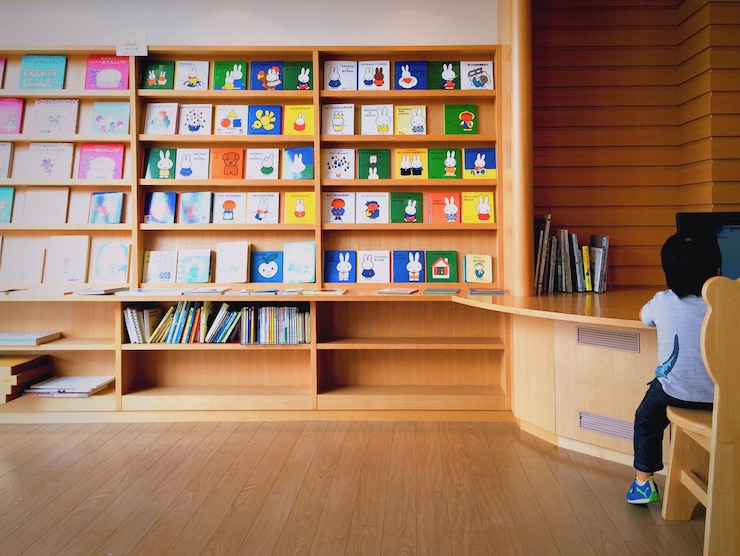 Foto niño sentado en la recepción de la biblioteca