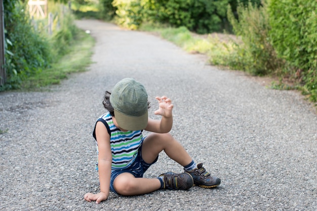 Niño sentado en el sendero