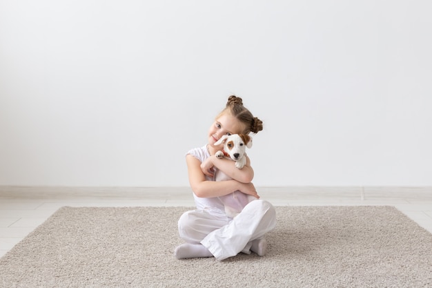 Niño sentado en el suelo con lindo cachorro jack russell