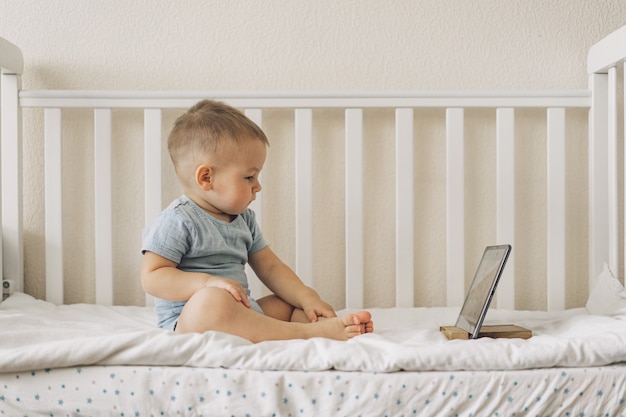 Niño sentado con una tableta en la habitación