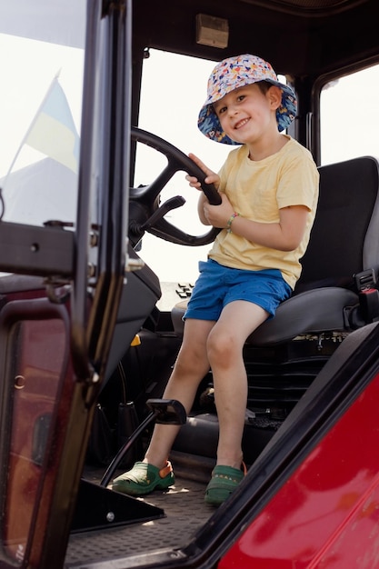 Niño sentado en el tractor de cabina