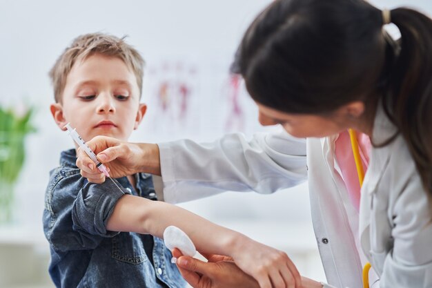 niño siendo vacunado por pediatra