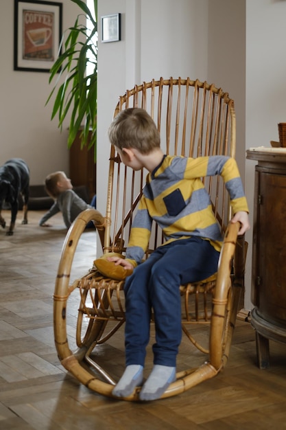 Niño en silla de balanceo en casa vintage hogar retro para la familia niño niño descansando en sillón