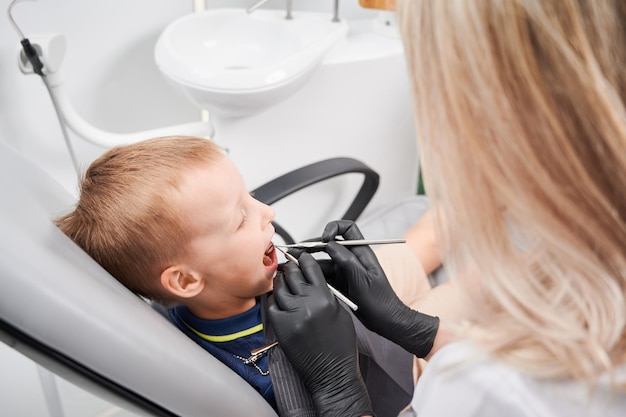 Niño en la silla del dentista durante el proceso de examen