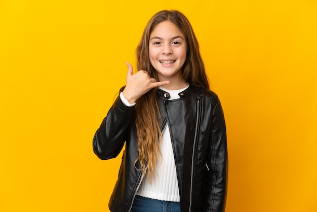 Niño sobre fondo amarillo aislado haciendo gesto de teléfono. Llámame señal