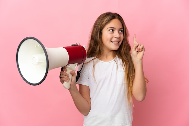 Niño sobre fondo rosa aislado sosteniendo un megáfono y con la intención de darse cuenta de la solución