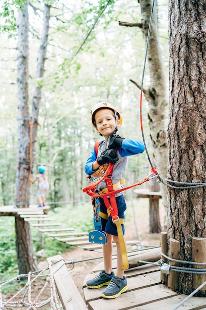 Niño se para sobre una plataforma de madera en un equipo de seguridad en un parque de atracciones