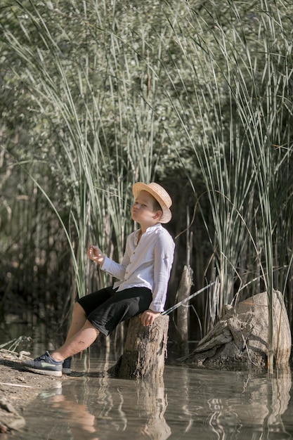 Niño solitario admirando la belleza del lago de verano en Grecia
