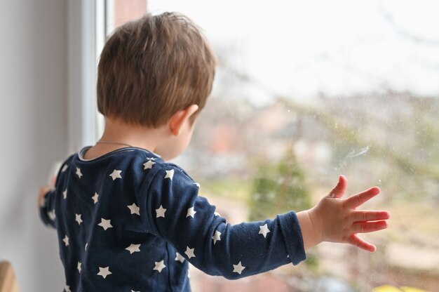 Niño solitario junto a la ventana