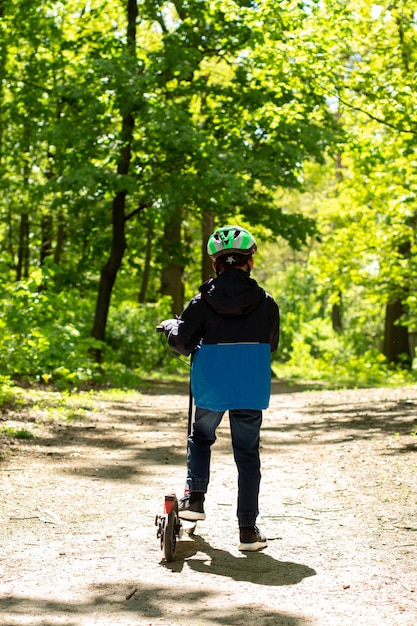 Niño solo en el parque en una moto con casco