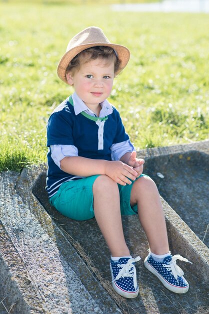 Un niño con sombrero se divierte en el parque en un día soleado de verano