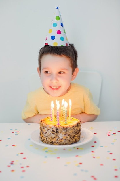 Foto niño con sombrero de fiesta pastel de cumpleaños