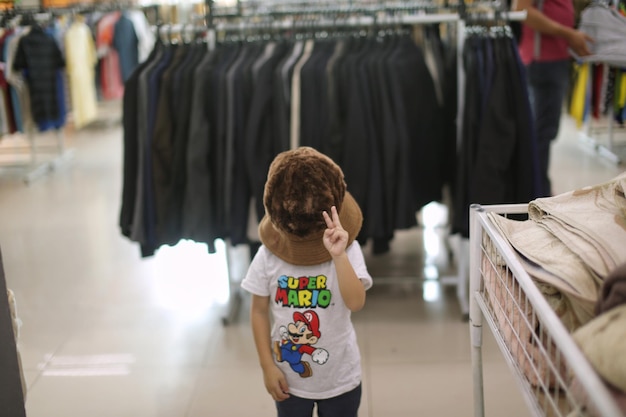 Foto niño con sombrero grande en la tienda de paquetes