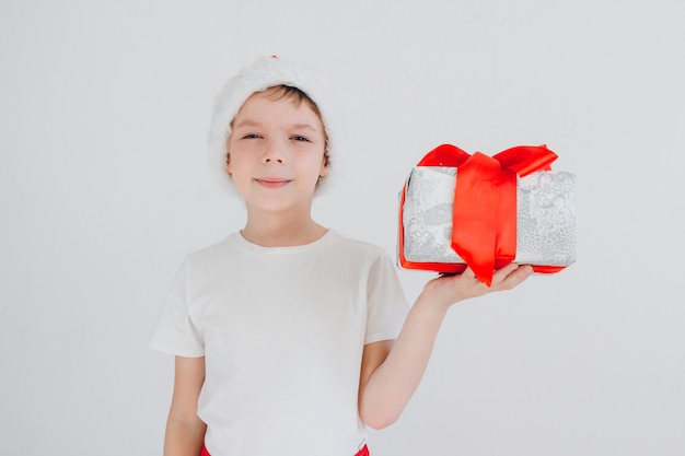 El niño con sombrero rojo de Santa con caja de regalo