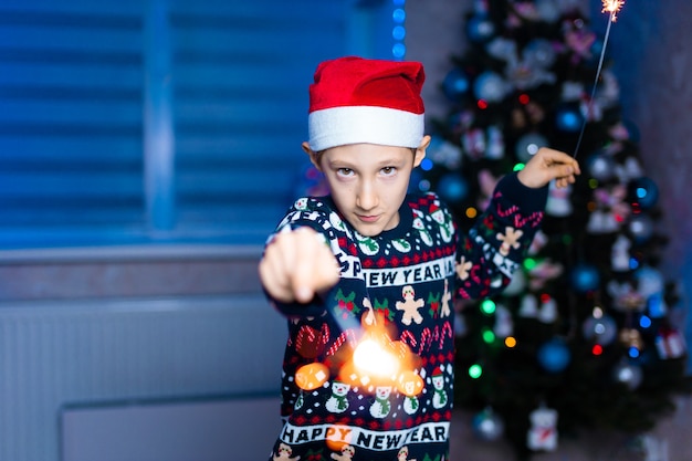 niño con sombrero de santa claus con bengalas