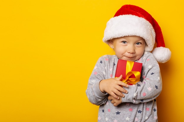 Niño con un sombrero de Santa Claus tiene un regalo