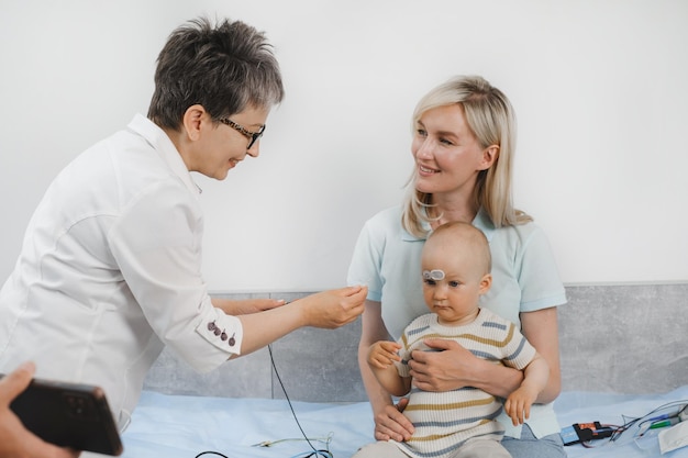 Foto niño sometido a un examen de audición por un audiólogo