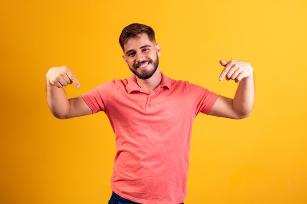 Niño sonriendo a la cámara apuntando hacia abajo con el concepto aquí.