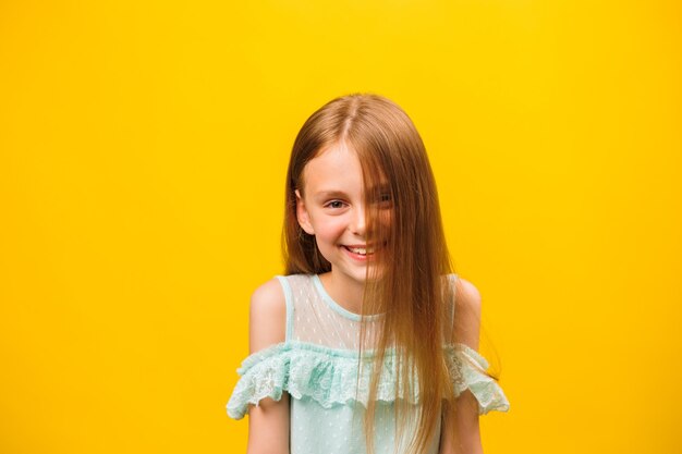 Niño sonriendo felizmente con el cabello rubio mirando con satisfacción frente a la cámara siendo