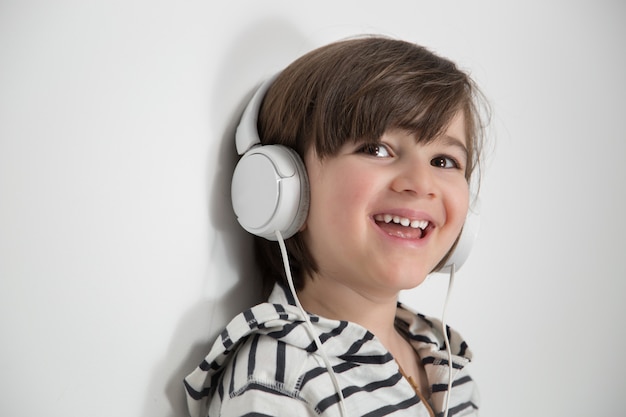 Foto niño sonriente con auriculares puestos