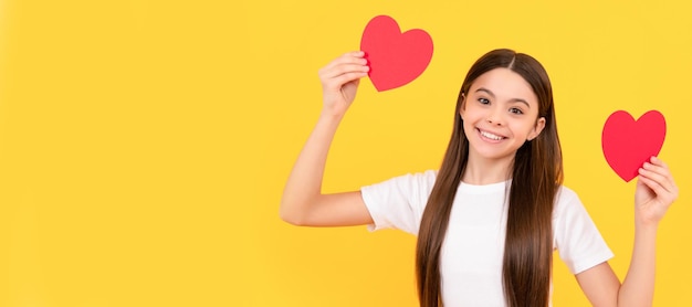 Niño sonriente con corazón rojo sobre fondo amarillo día de san valentín Retrato de niña niño con símbolo de amor de corazón cartel horizontal Encabezado de banner con espacio de copia