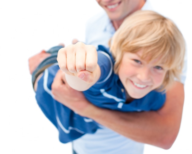 Niño sonriente disfrutando de paseo a cuestas con su padre