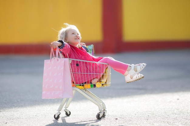 Niño sonriente feliz compras niño con carro