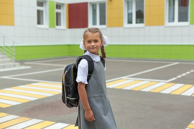 Niño sonriente feliz va a la escuela por primera vez