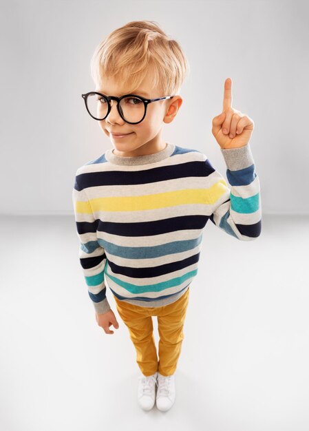 niño sonriente con gafas y suéter a rayas