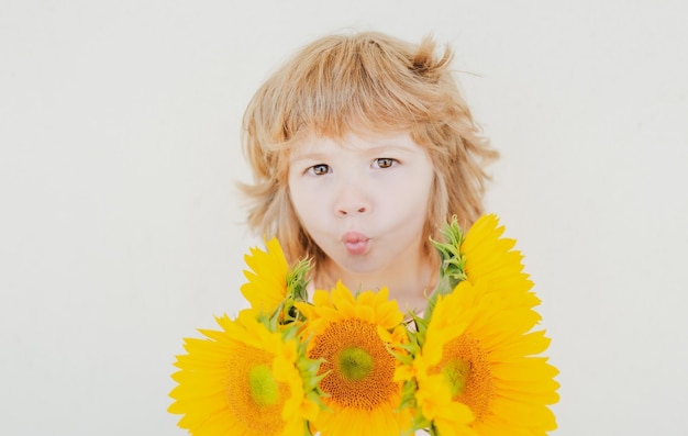 Niño sonriente con girasoles niño feliz con ramo de flores lindo niño encantador romántico y sorpresa