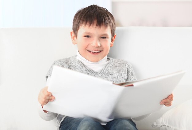 Niño sonriente leyendo un libro en la foto de la guardería con espacio para copiar