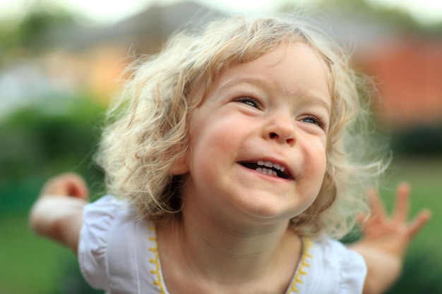 Niño sonriente en el parque de verano Profundidad de campo