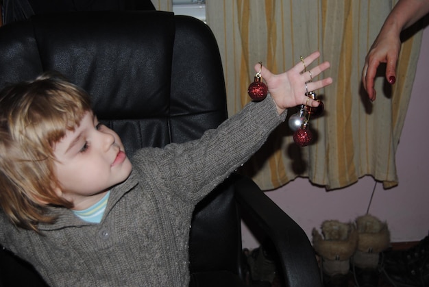 Foto niño sonriente sentado en una silla en casa