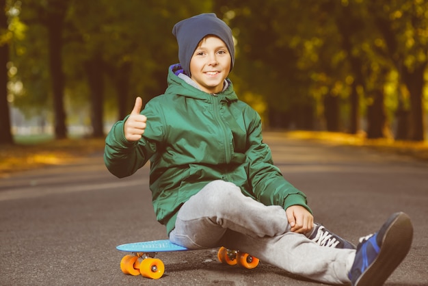 Niño sonriente sentado en tablero de centavo